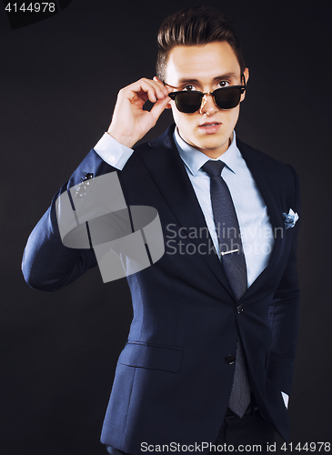 Image of young pretty business man standing on black background, modern h