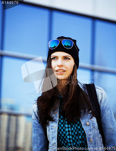 Image of young pretty girl near business building walking