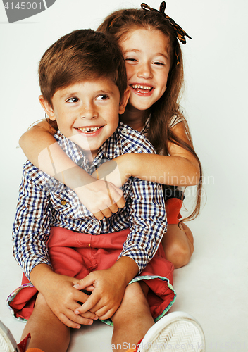 Image of little cute boy and girl hugging playing on white background, ha