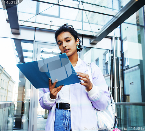 Image of young cute indian girl at university building sitting on stairs