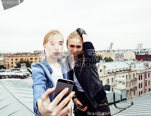 Image of two cool blond real girls friends making selfie on roof top, lif