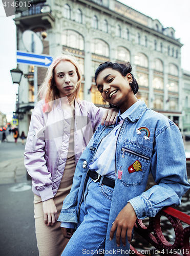 Image of Two teenage girls infront of university building smiling, having