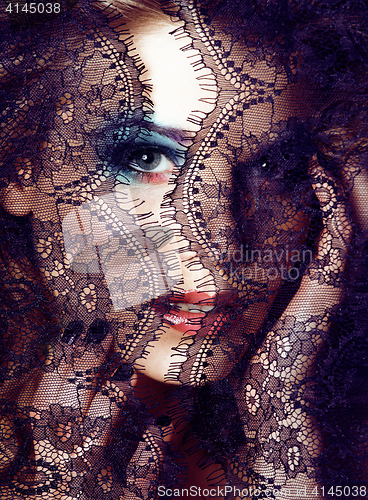 Image of Portrait of beauty blond young woman through black lace close up