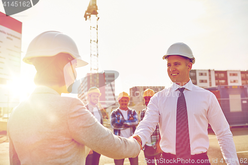 Image of builders making handshake on construction site