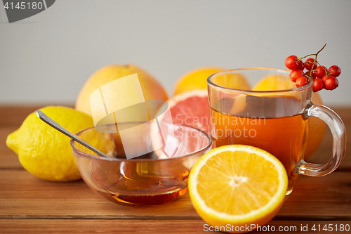 Image of tea with honey, lemon and rowanberry on wood