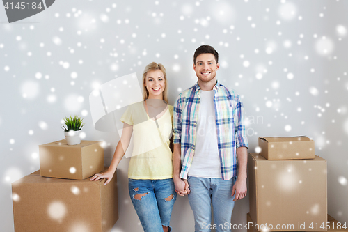 Image of smiling couple with big boxes moving to new home