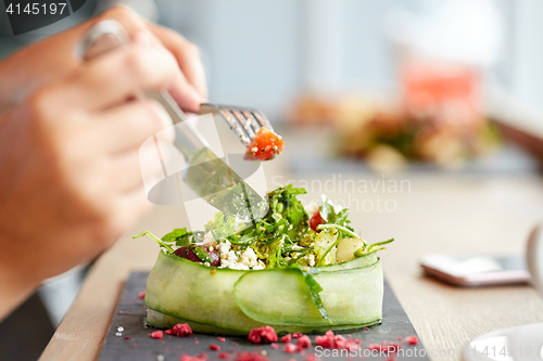 Image of woman eating cottage cheese salad at restaurant