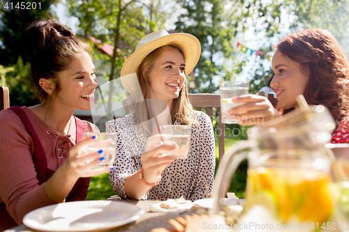 Image of happy friends having party at summer garden