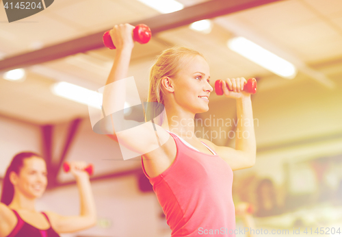 Image of group of smiling people working out with dumbbells