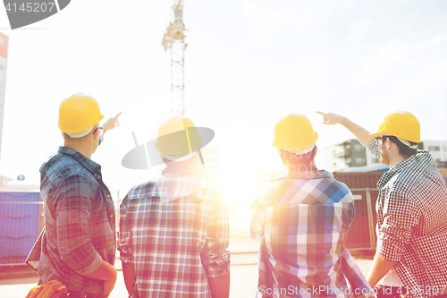 Image of group of builders in hardhats at construction site