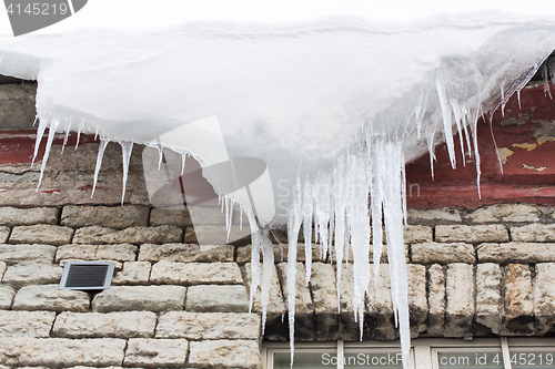 Image of icicles and snow hanging from building roof