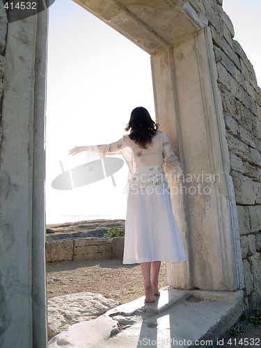 Image of Barefoot Girl Looking Straight Holding Ancient Ruins