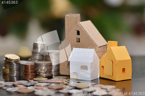 Image of Paper house and stacks of coins standing