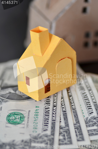 Image of Miniature paper made house stand on  money