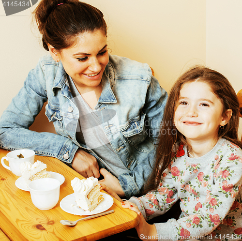 Image of young mother with daughter on kitchen drinking tea together hugg