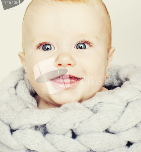 Image of little cute red head baby in scarf all over him close up isolate