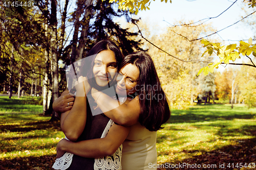 Image of mature real mother with daughter outside autumn fall in park