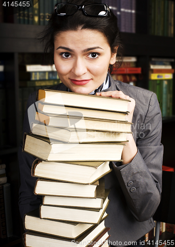 Image of young teen girl in library among books emotional close up bookwarm