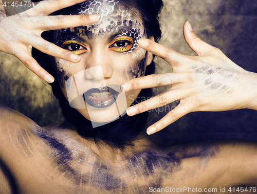 Image of fashion portrait of pretty young woman with creative make up like a snake