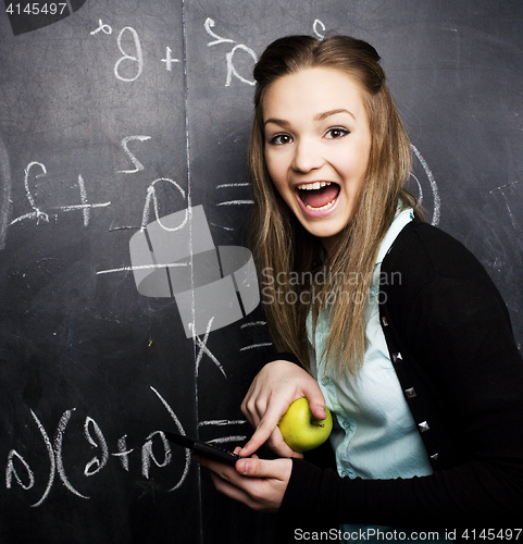 Image of portrait of happy cute student with book in classroom