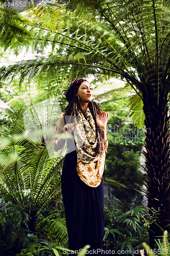 Image of Young cute smiling real stylish dressed woman in green palm park