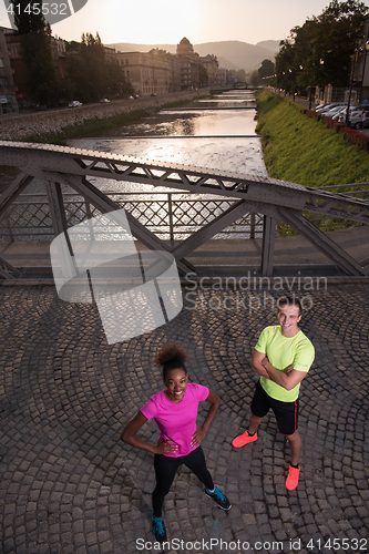 Image of portrait of a young multiethnic couple jogging in the city