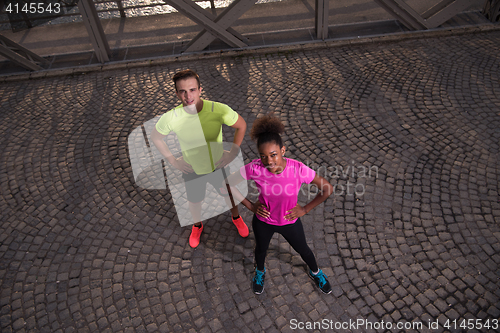 Image of portrait of a young multiethnic couple jogging in the city