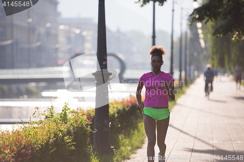 Image of african american woman jogging in the city