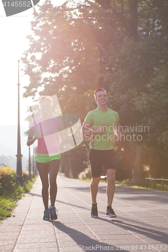 Image of young multiethnic couple jogging in the city