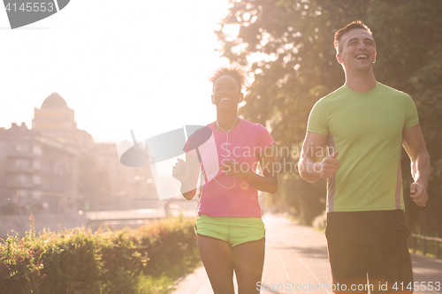 Image of young multiethnic couple jogging in the city
