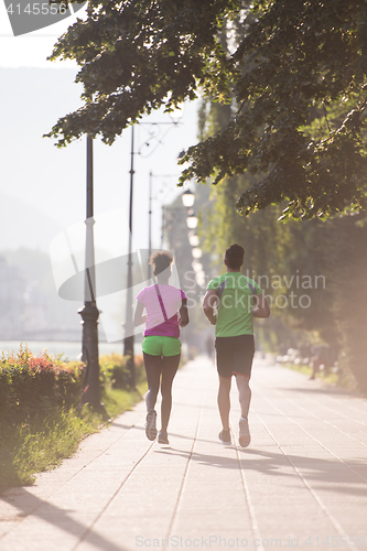 Image of young multiethnic couple jogging in the city