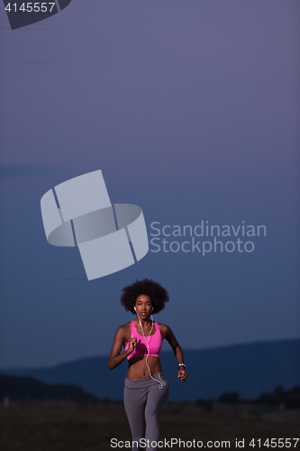 Image of Young African american woman jogging in nature