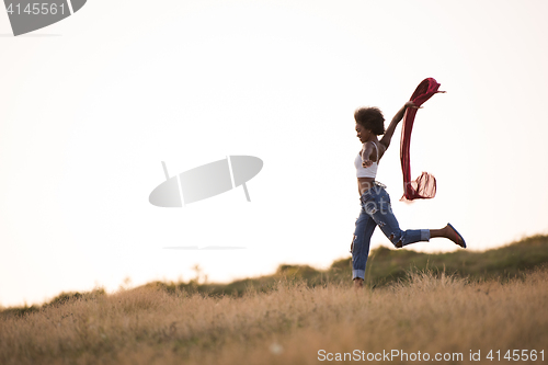 Image of black girl dances outdoors in a meadow