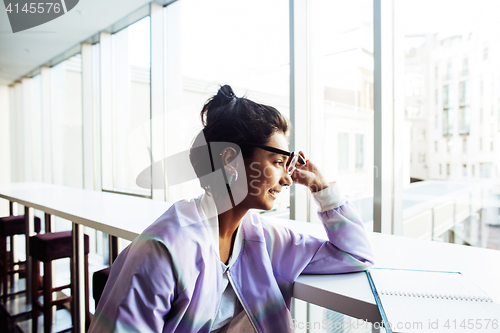 Image of young cute hipster girl student sitting in cafe with notebook re