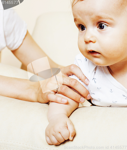 Image of little cute toddler baby boy playing on chair, mother insures holding hand, lifestyle people concept