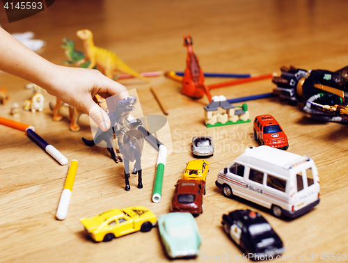 Image of children playing toys on floor at home, little hand in mess, free education