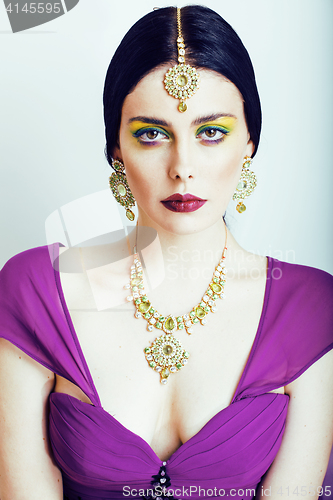 Image of young pretty caucasian woman like indian in ethnic jewelry close up on white, bridal makeup