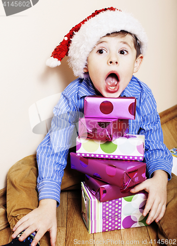 Image of little cute boy with Christmas gifts at home. close up emotional