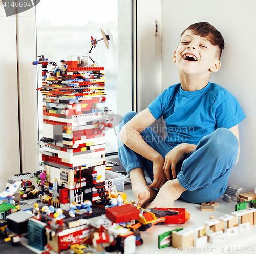 Image of little cute preschooler boy playing with toys at home happy smiling kid, lifestyle people concept