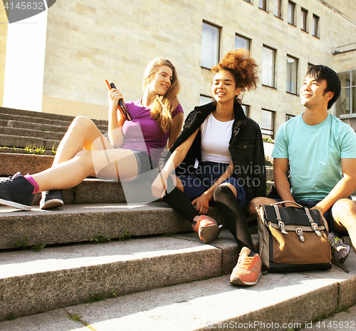 Image of cute group of teenages at the building of university with books 