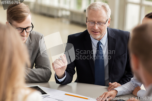 Image of architects with tablet pc and blueprint at office