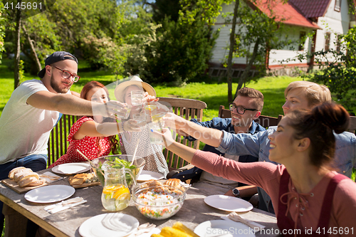 Image of happy friends having dinner at summer garden party