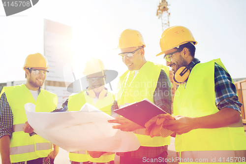 Image of group of builders with tablet pc and blueprint