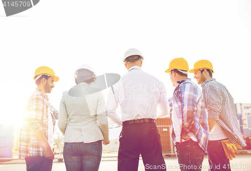 Image of group of builders and architects at building site