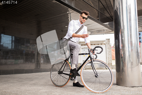 Image of man with bicycle and smartphone on city street