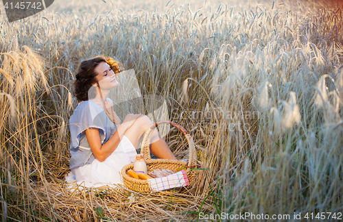 Image of middle aged beautiful smiling woman with basket outdoors