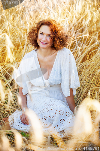 Image of middle aged pretty smiling woman outdoors