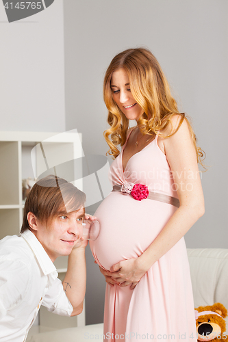 Image of man listening pregnant belly