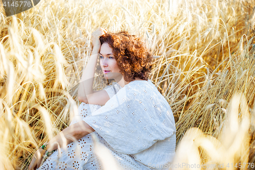 Image of middle aged beautiful smiling woman in wheat field