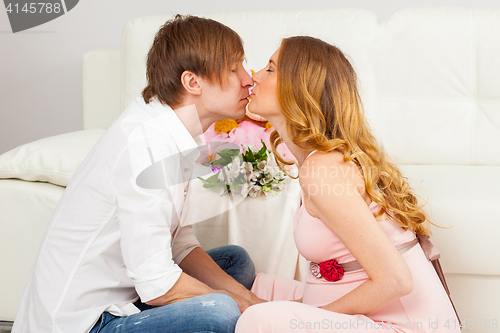Image of man and pregnant woman kissing